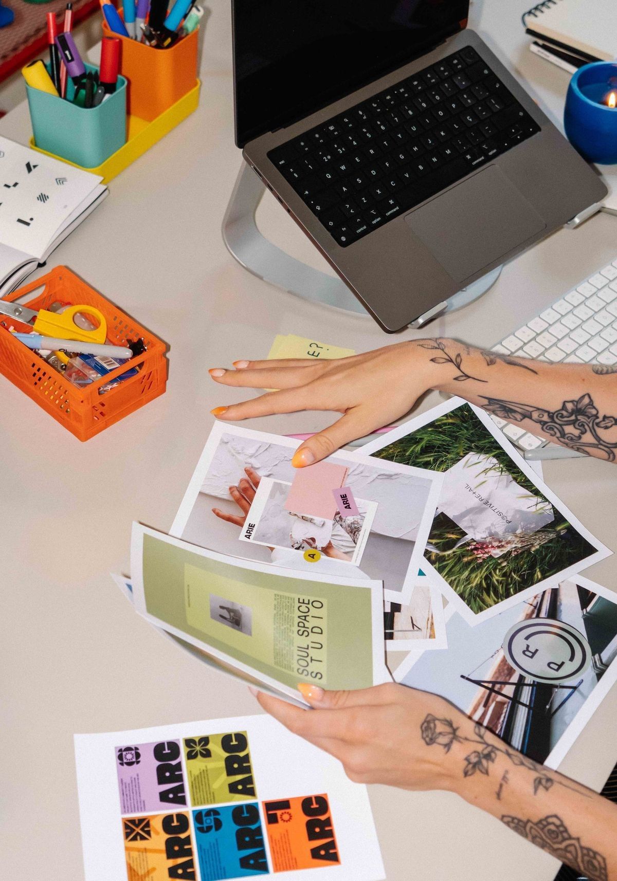 Illustrative stock photograph of hands sorting printed brand materials, type sheets and colour prints on a desk