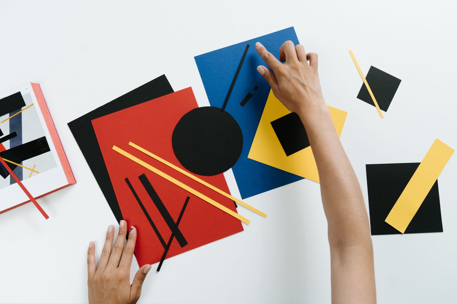 Illustrative stock photograph of hands arranging geometric paper shapes